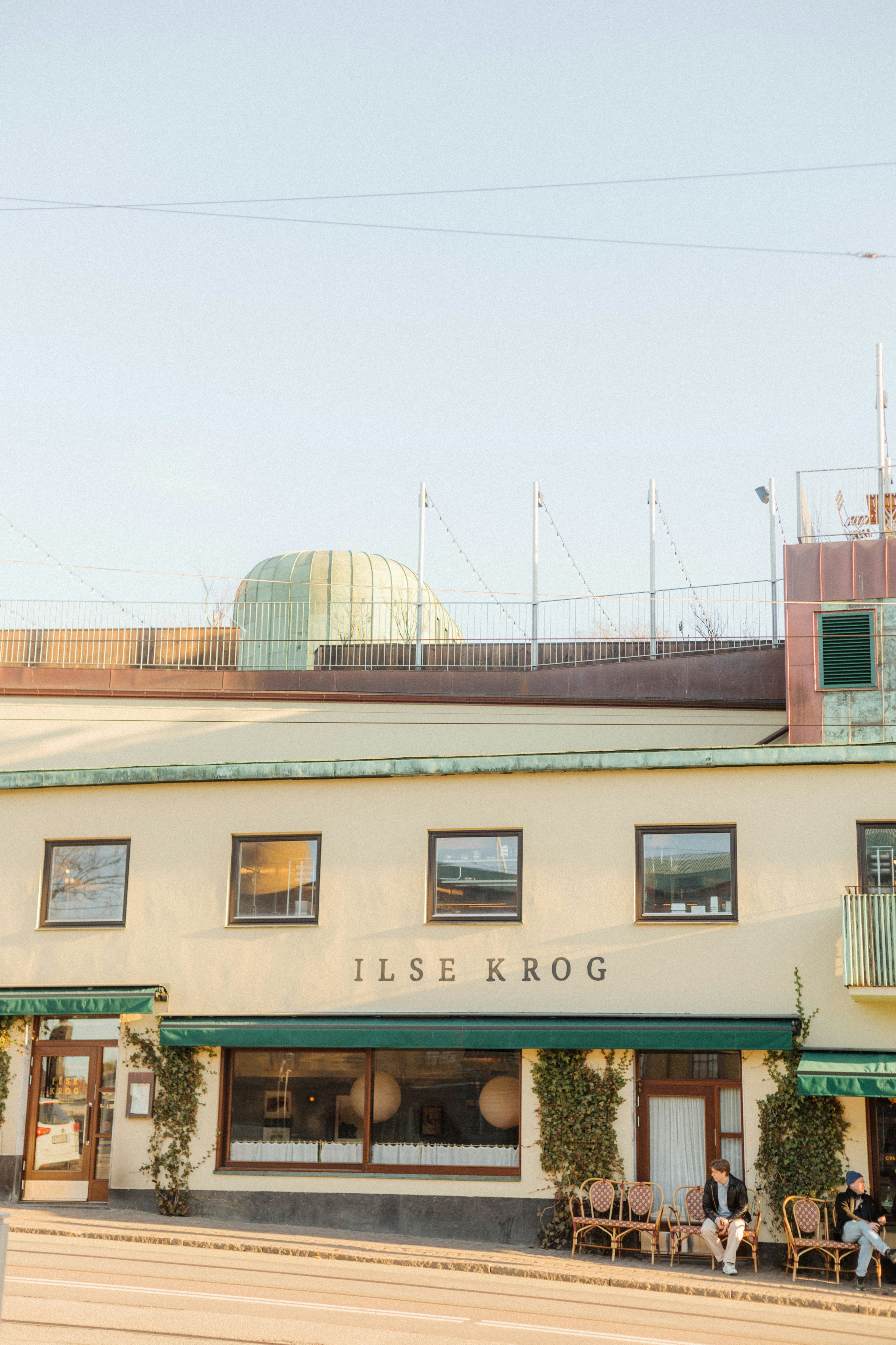 Restaurant ilse krog with people sitting outside.