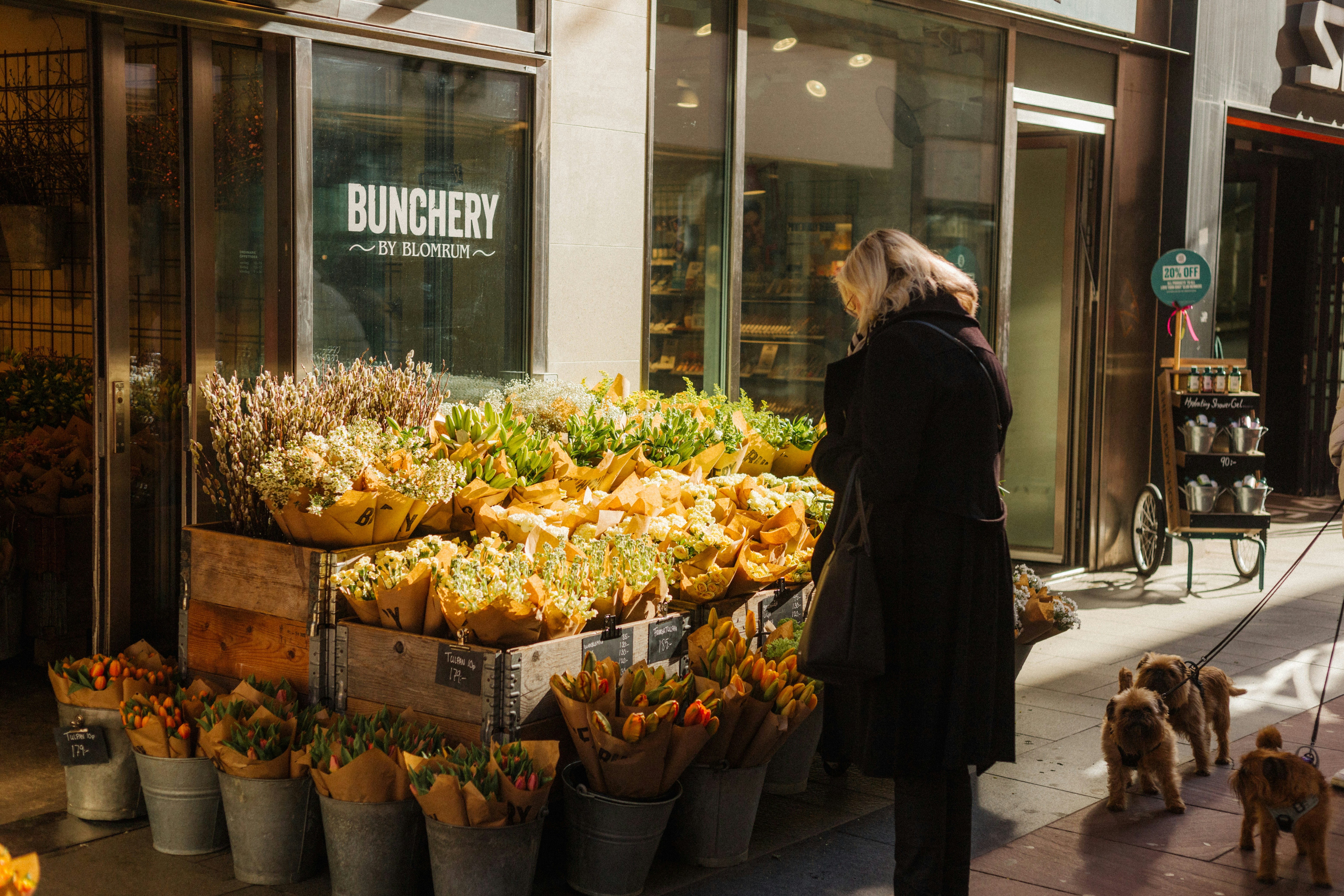 woman and dogs shop at a flower stall