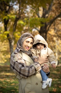Mother and baby pose for a photo in autumn.