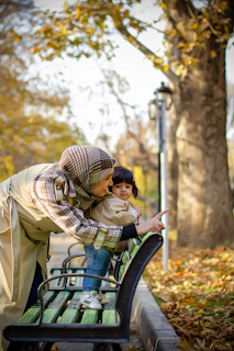 Mother and child point at something in the park.