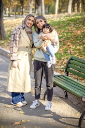 Three generations smiling in a park together.