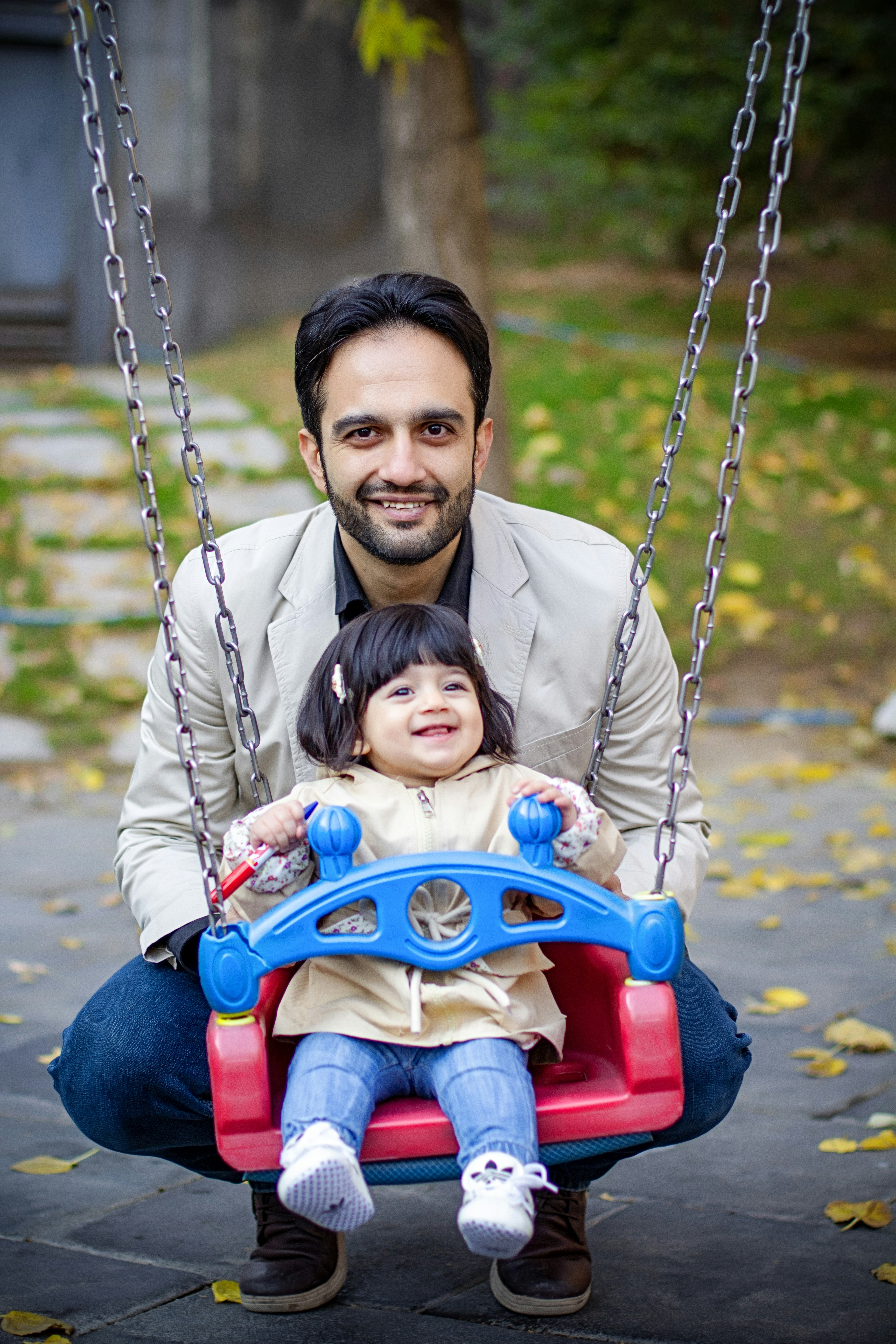 A father and daughter are enjoying a swing.