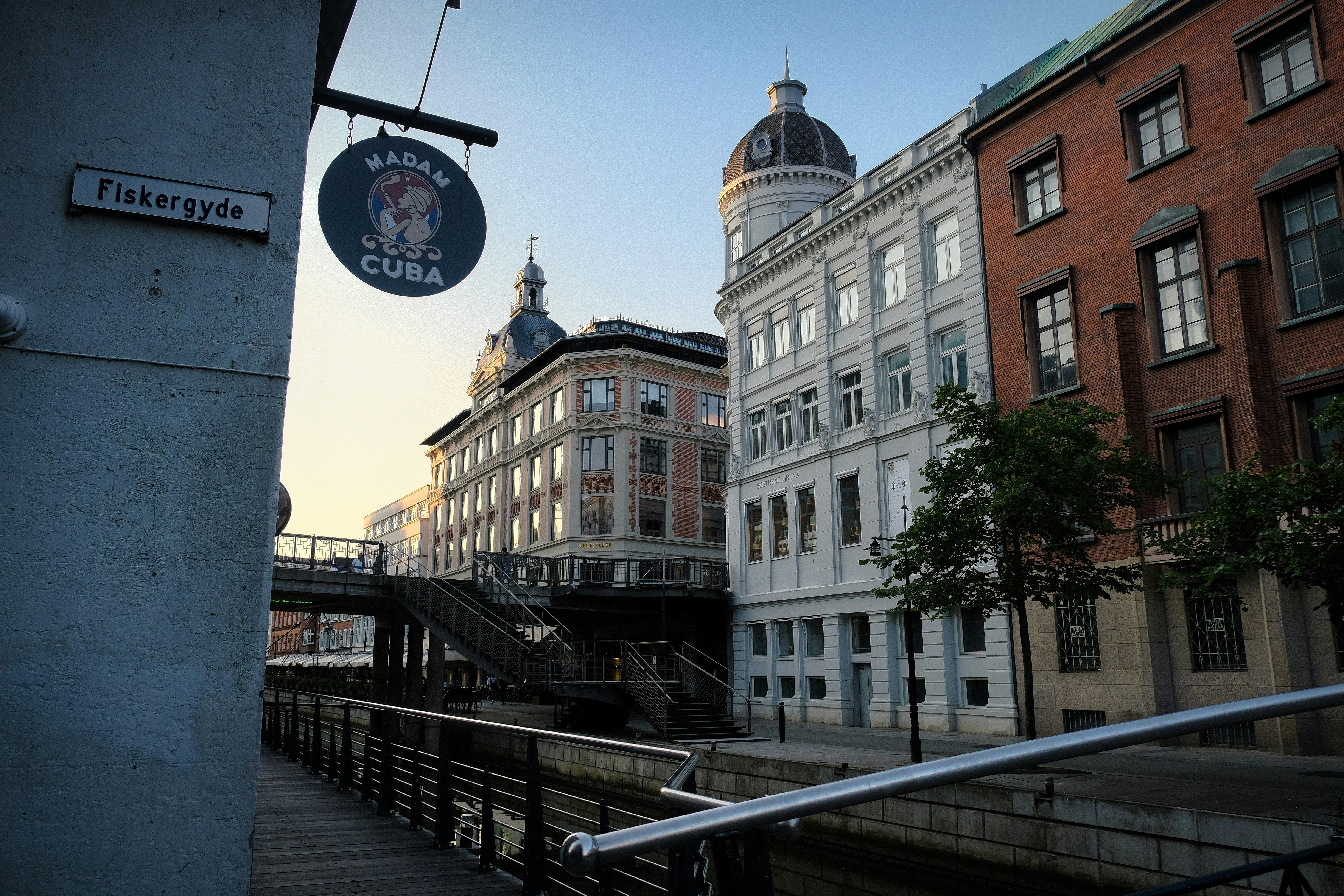 A picturesque city street with buildings and a bridge.