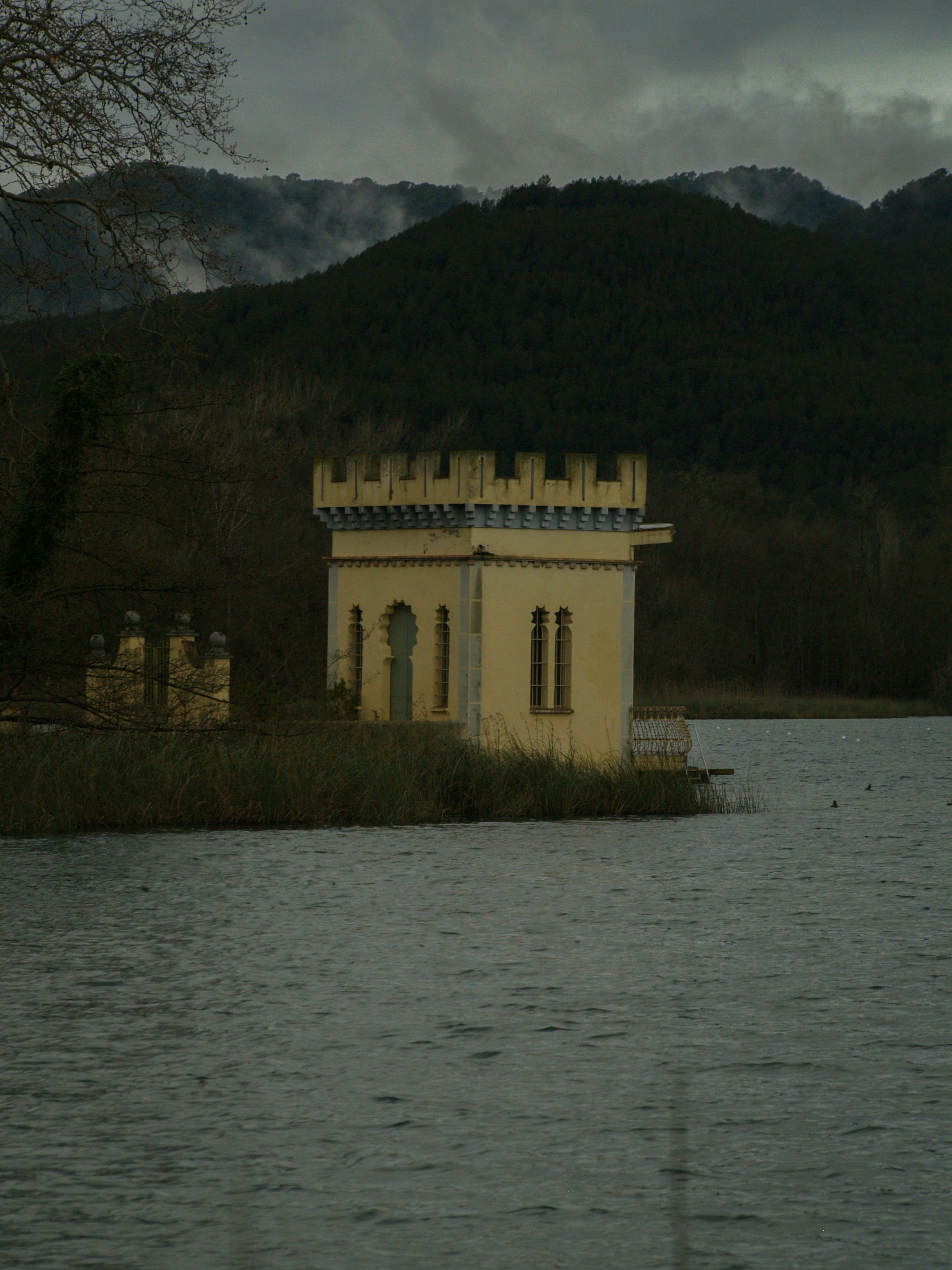Um pequeno edifício semelhante a um castelo fica à beira da água.