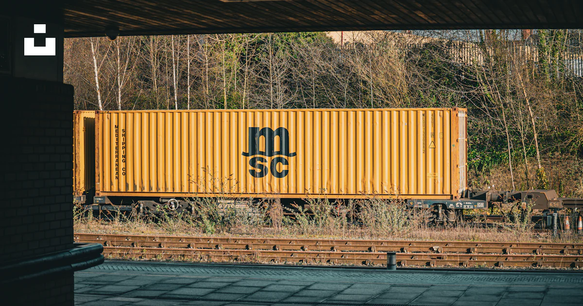 Yellow shipping container on train tracks. photo – Free Train Image on ...