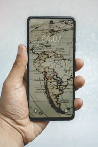A smartphone displays a vintage map of the americas.