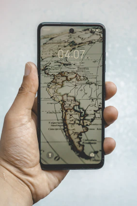 A smartphone displays a vintage map of the americas.