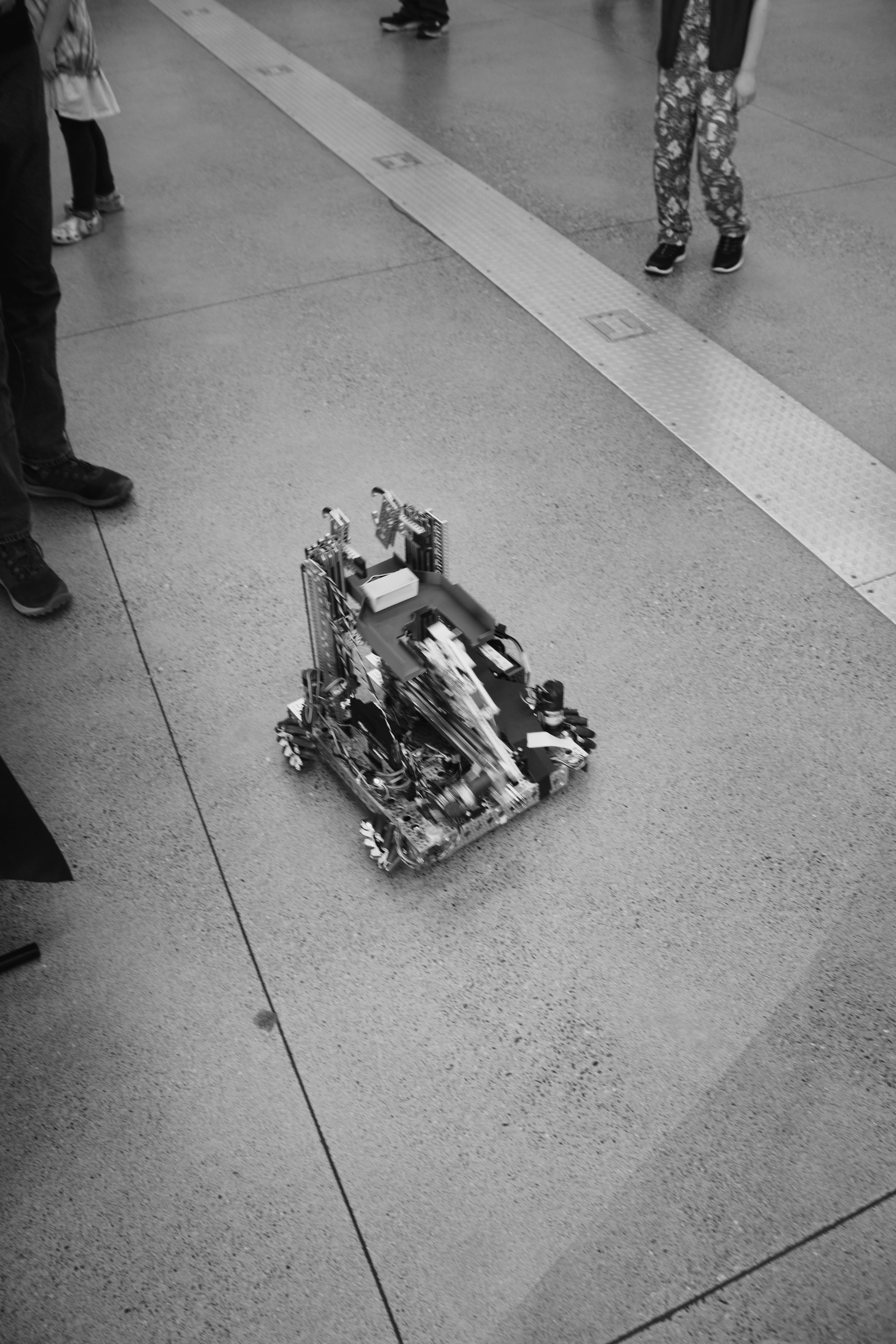 A robot is on the floor with people around it.