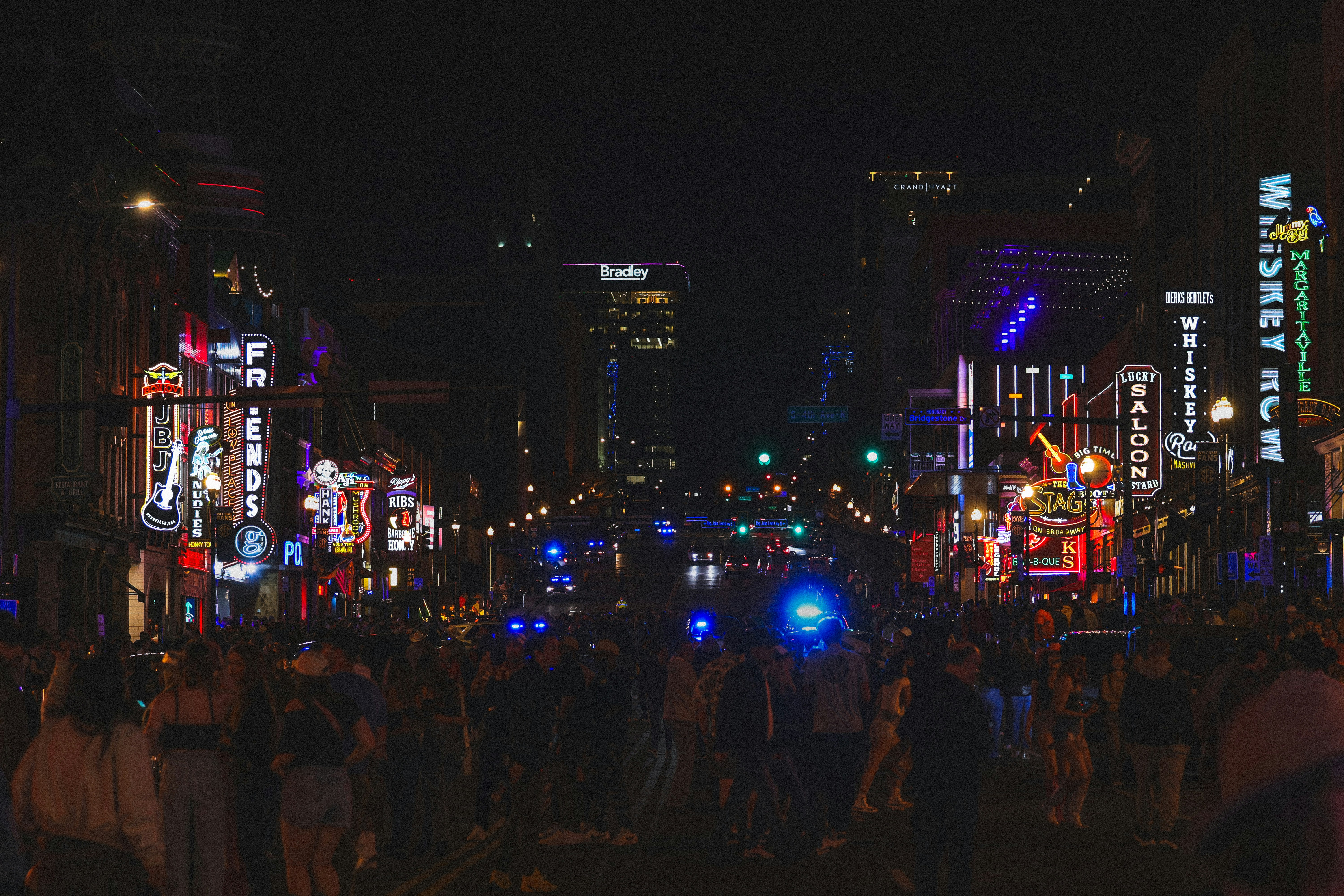 A vibrant, brightly-lit city street at night.