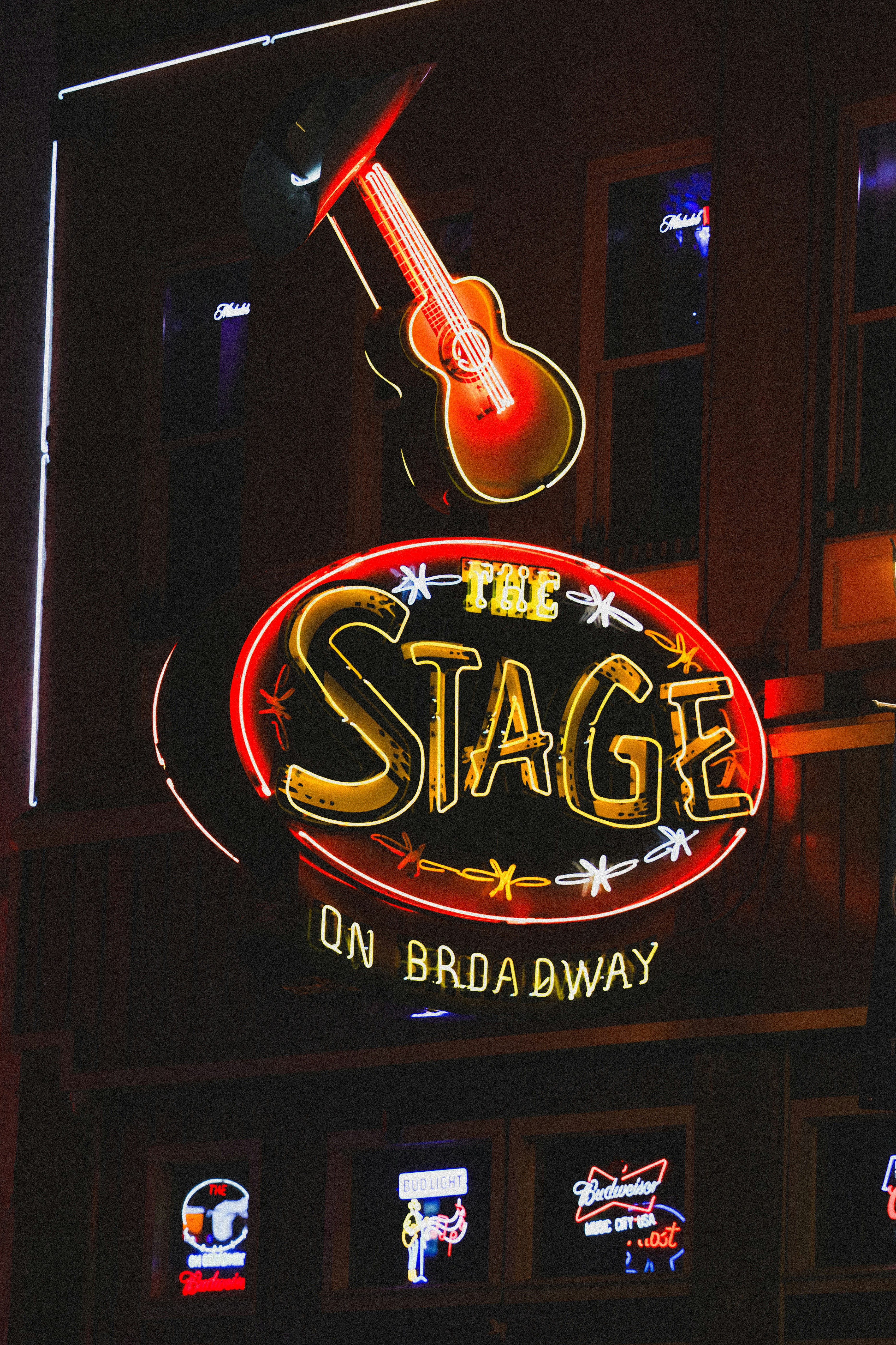 The stage on broadway has a neon sign.