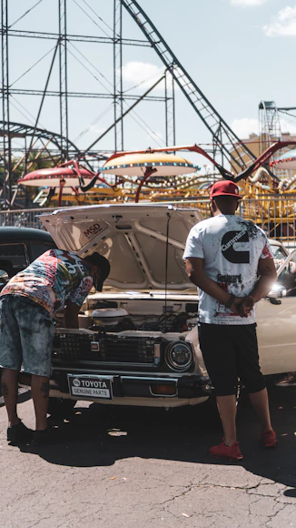 Two men inspecting a classic car.