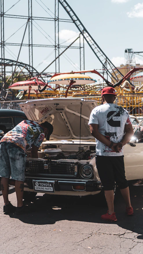 Two men inspecting a classic car.