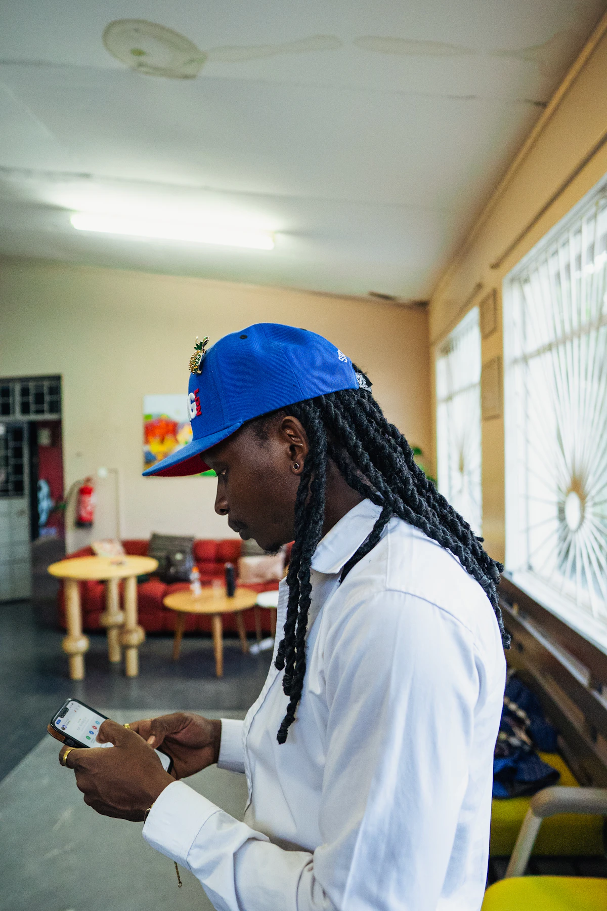 A man with braids looks at his phone