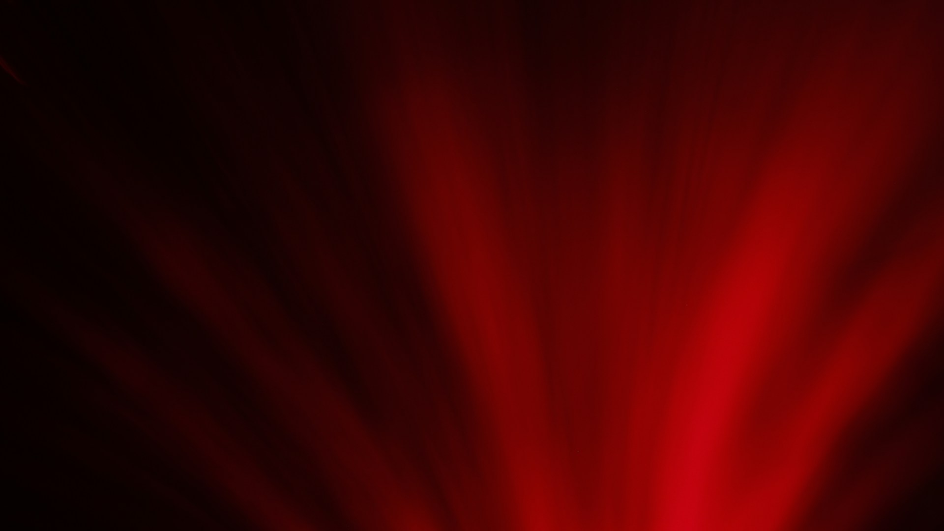 Red light beams burst from darkness.