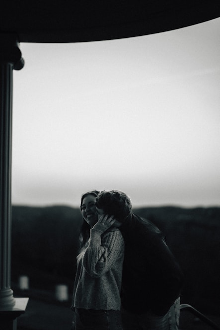 A couple shares a tender moment outdoors.