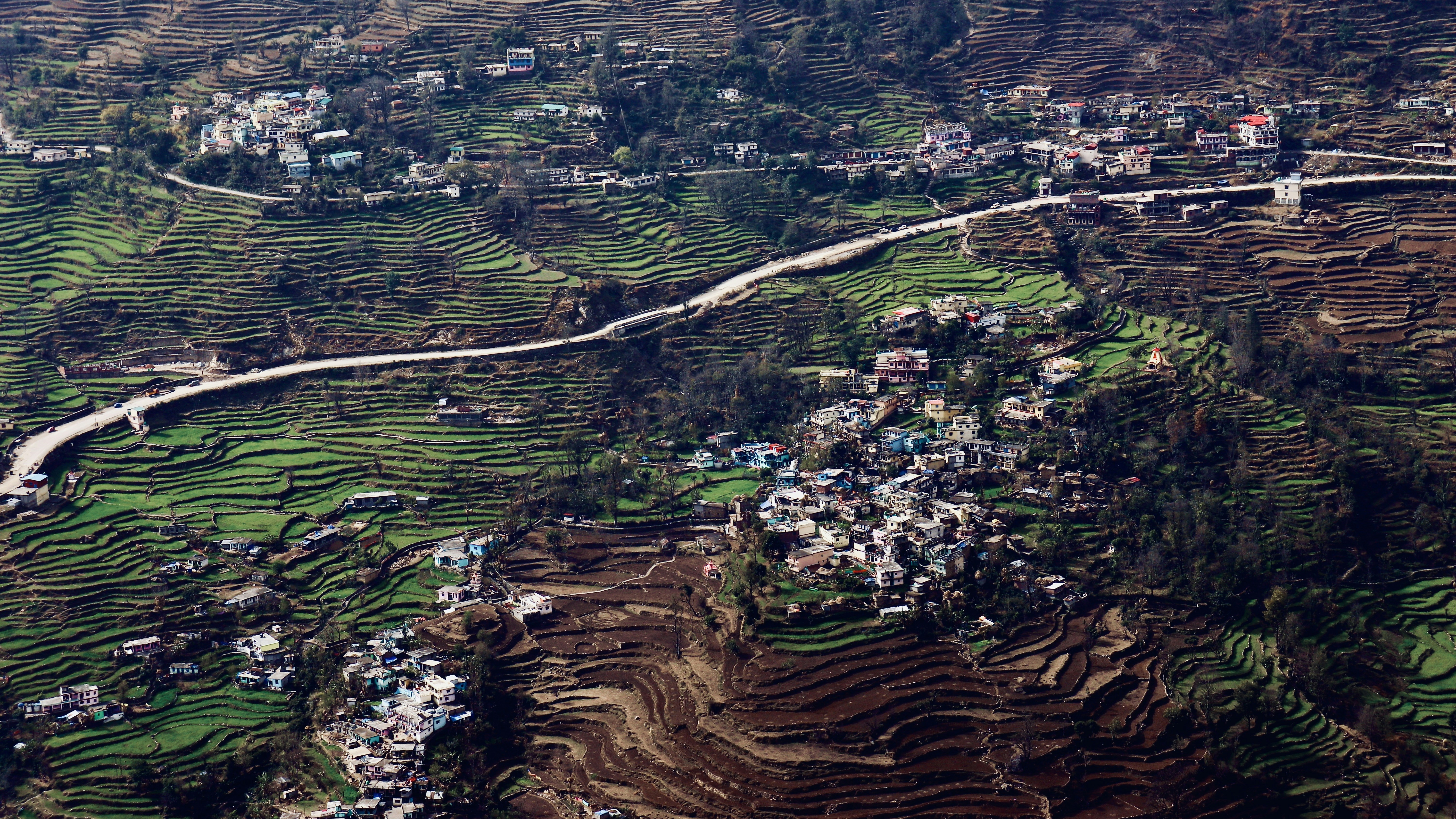 Former US President Donald Trump and Indian Prime Minister Narendra Modi shaking hands warmly at a diplomatic event, with flags of both nations in the background.
