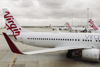 Virgin australia planes are on the ground at the airport.