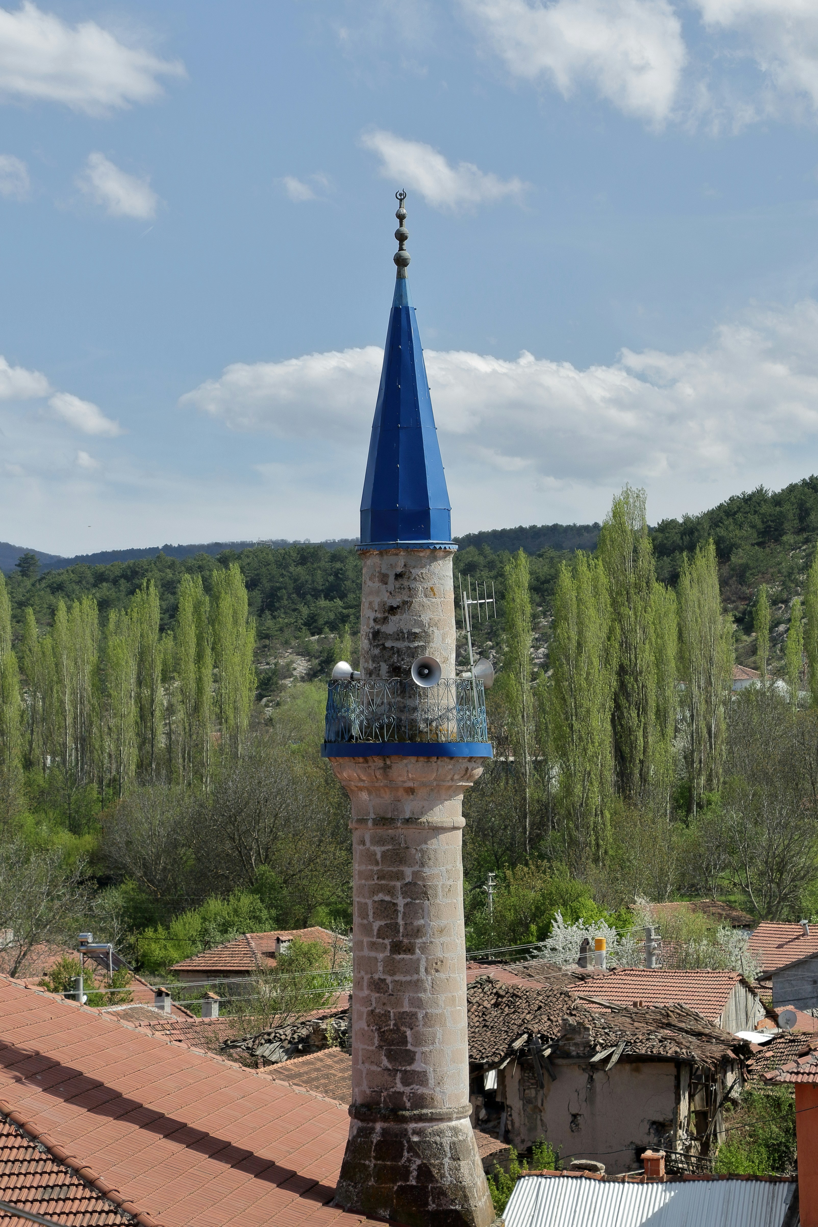A mosque minaret stands tall against a scenic view.