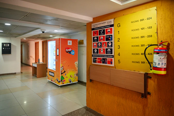 A hallway contains a vending machine and fire extinguisher.