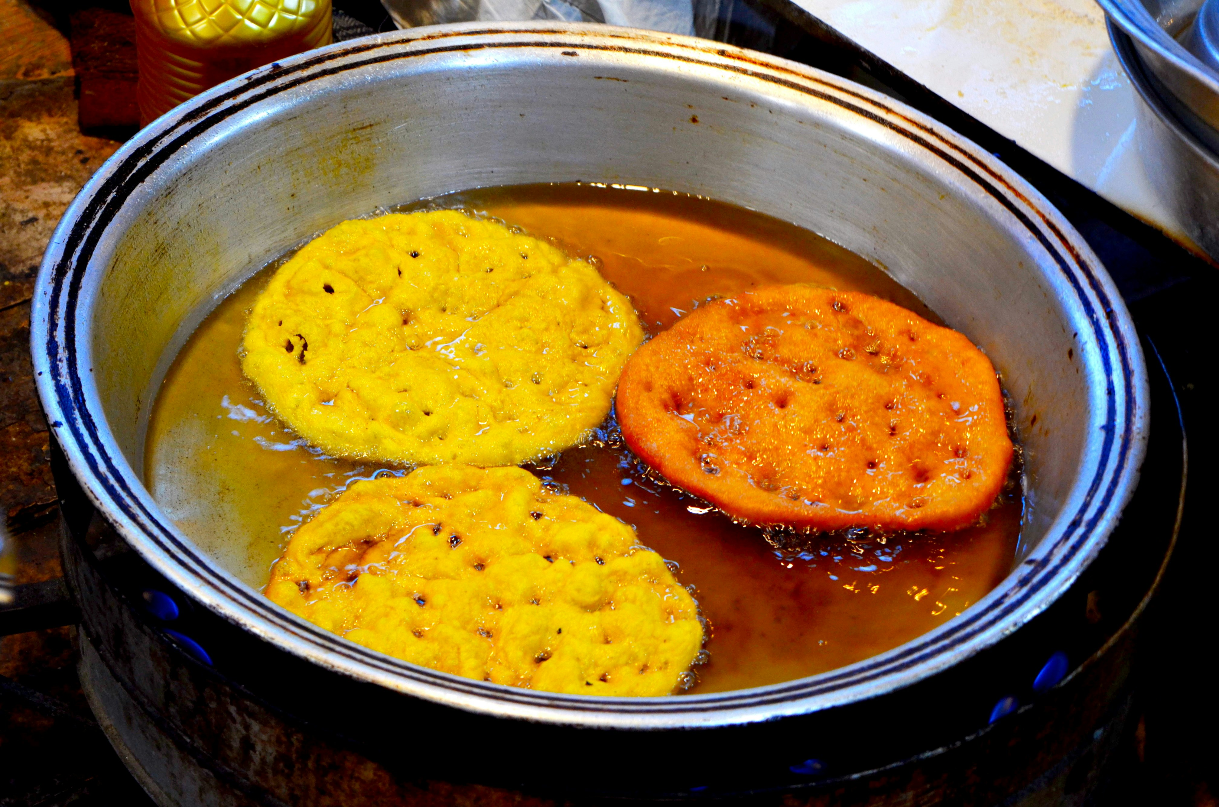 Frying some delicious, round, yellow foods.