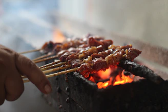Meat skewers cooking over a hot grill