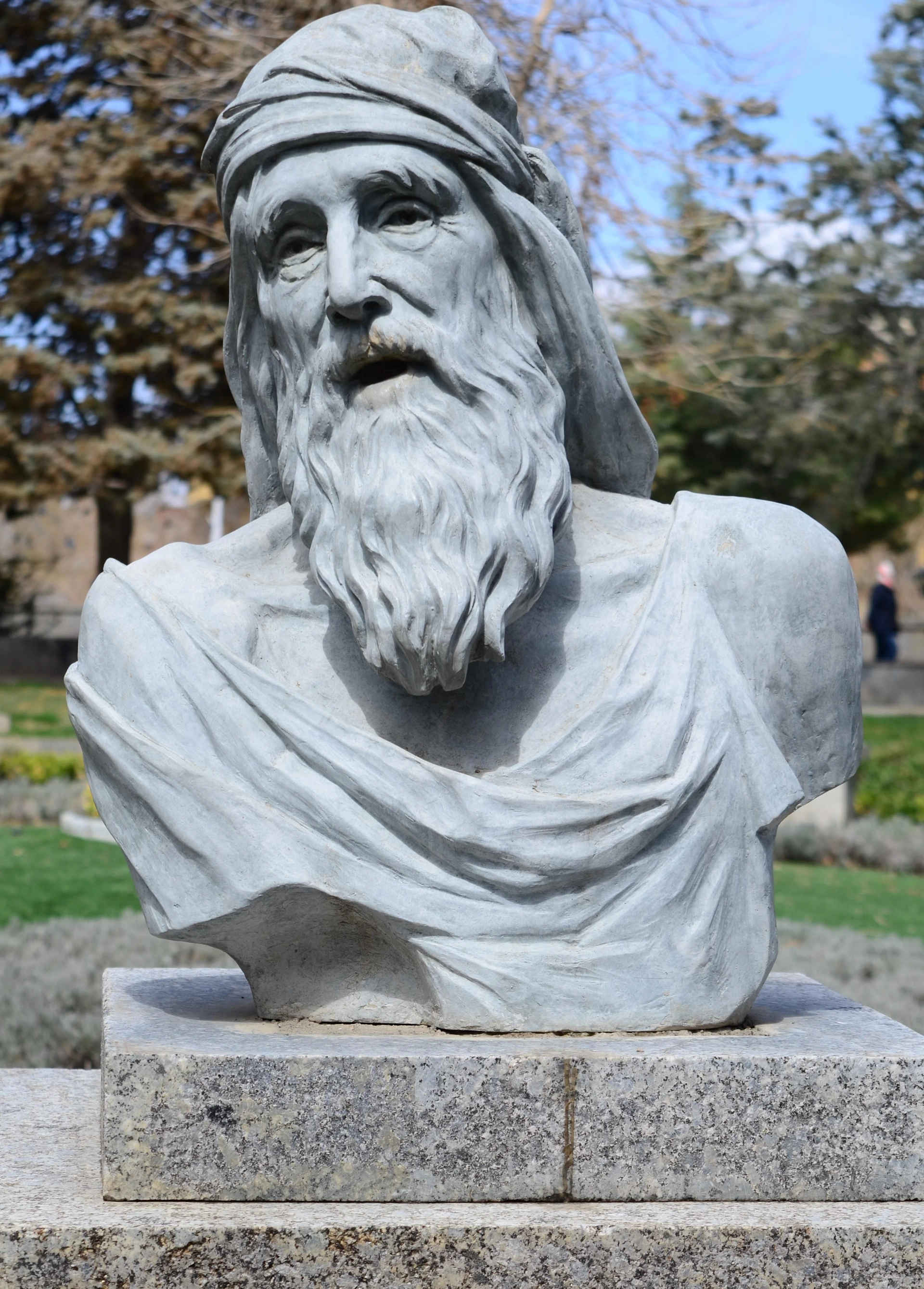 A stone bust of an old, bearded man.