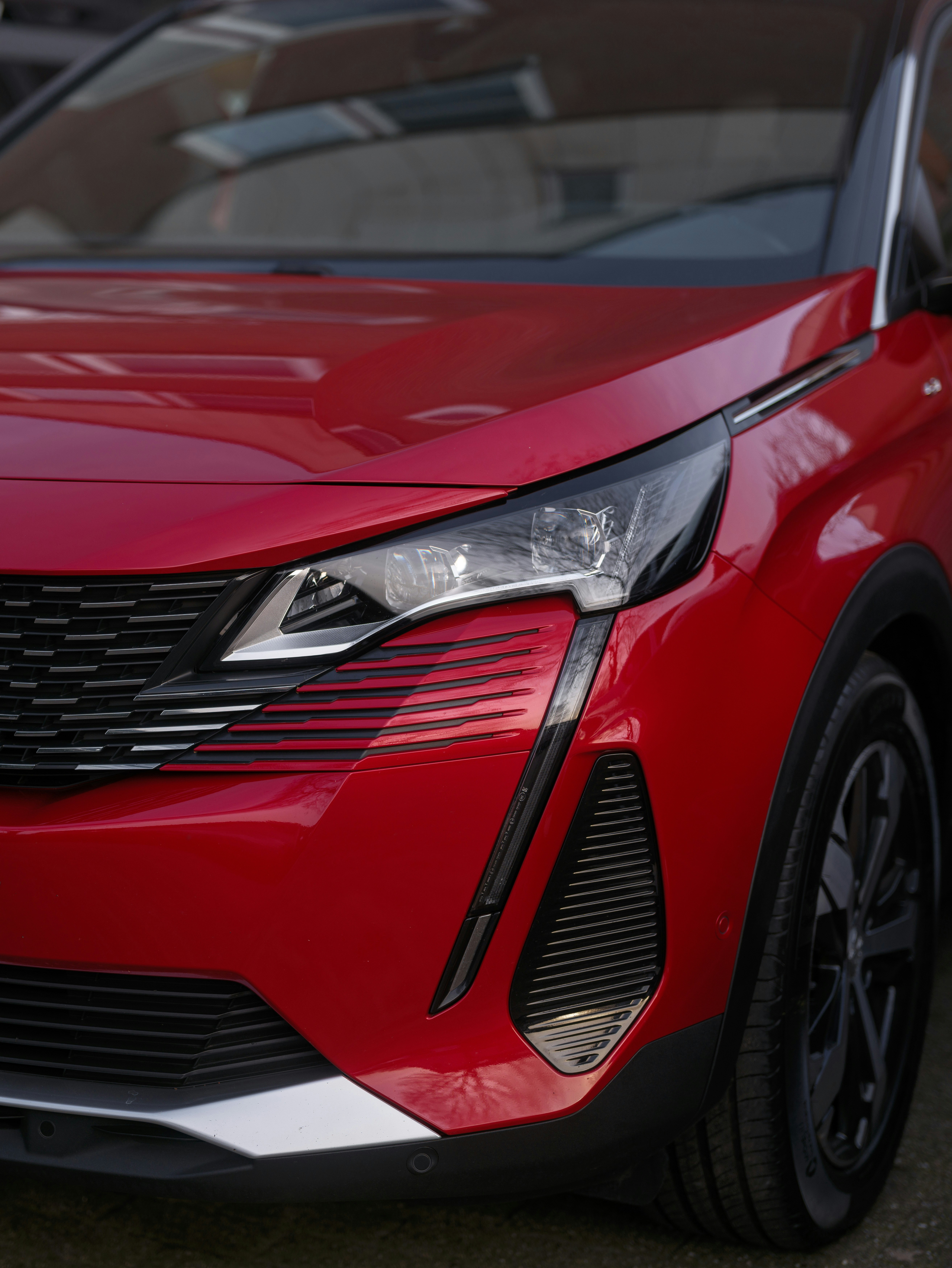 Red peugeot car's front end.