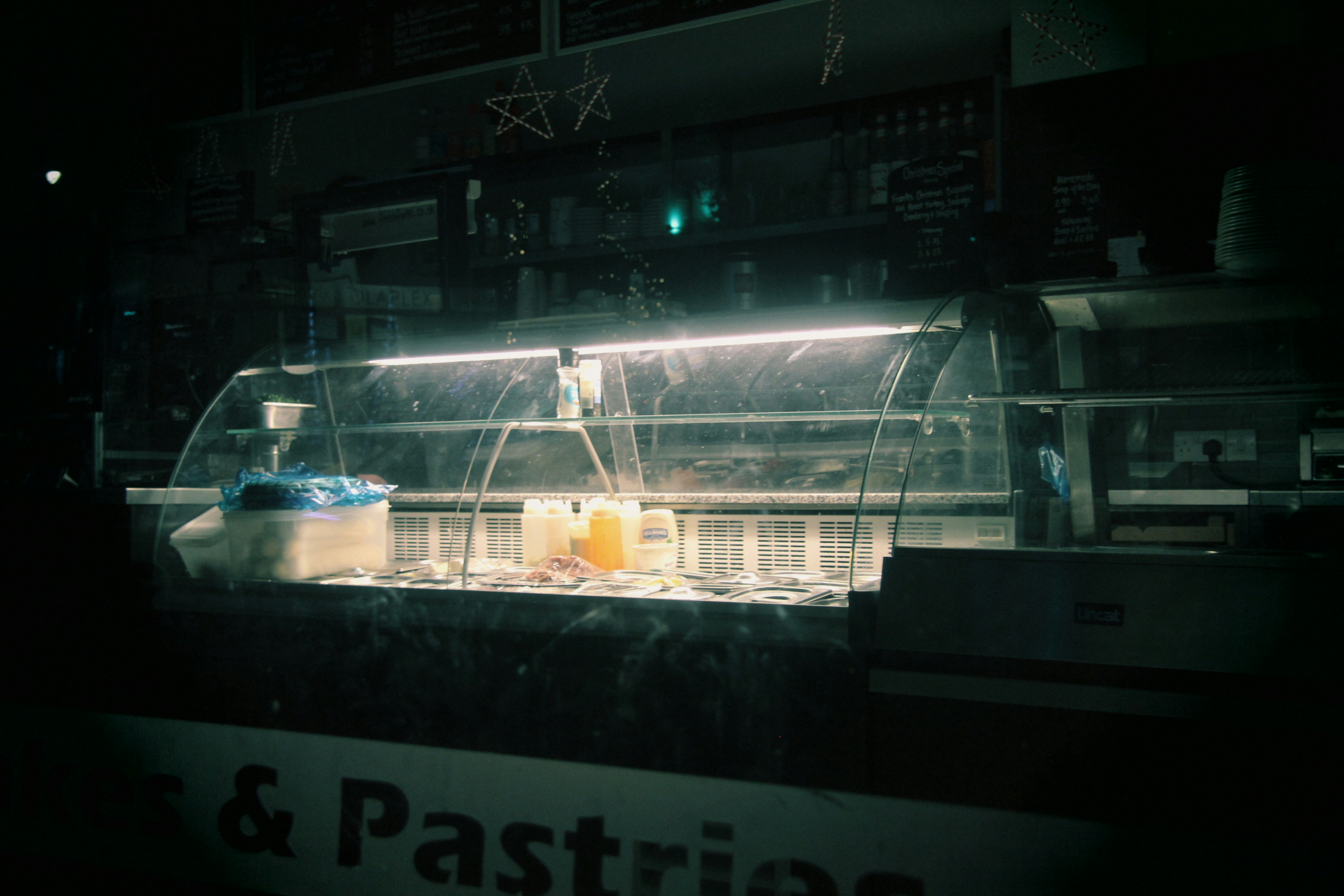 A dessert display case is lit in the dark.