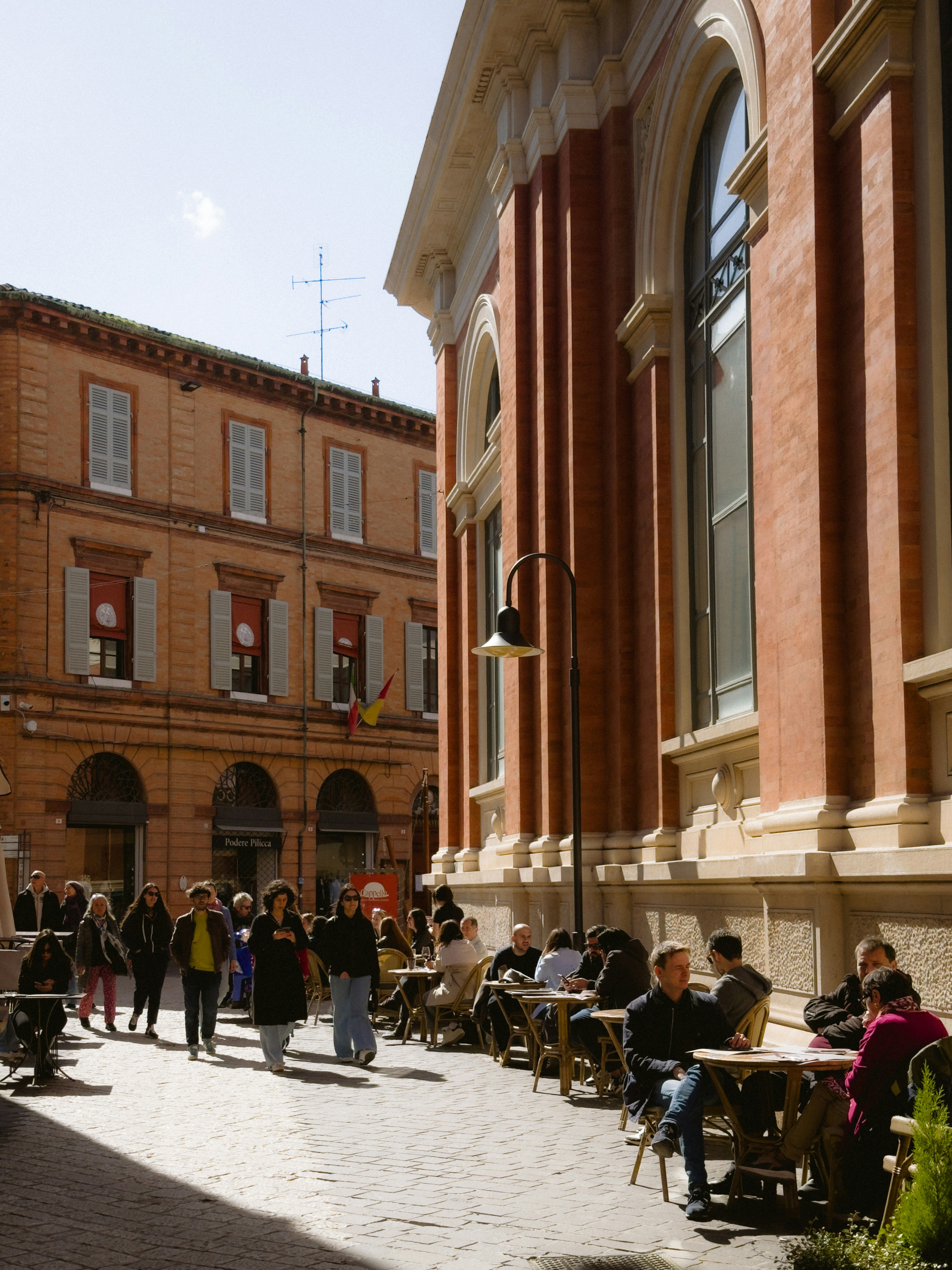 People enjoy a sunny day at outdoor cafes.