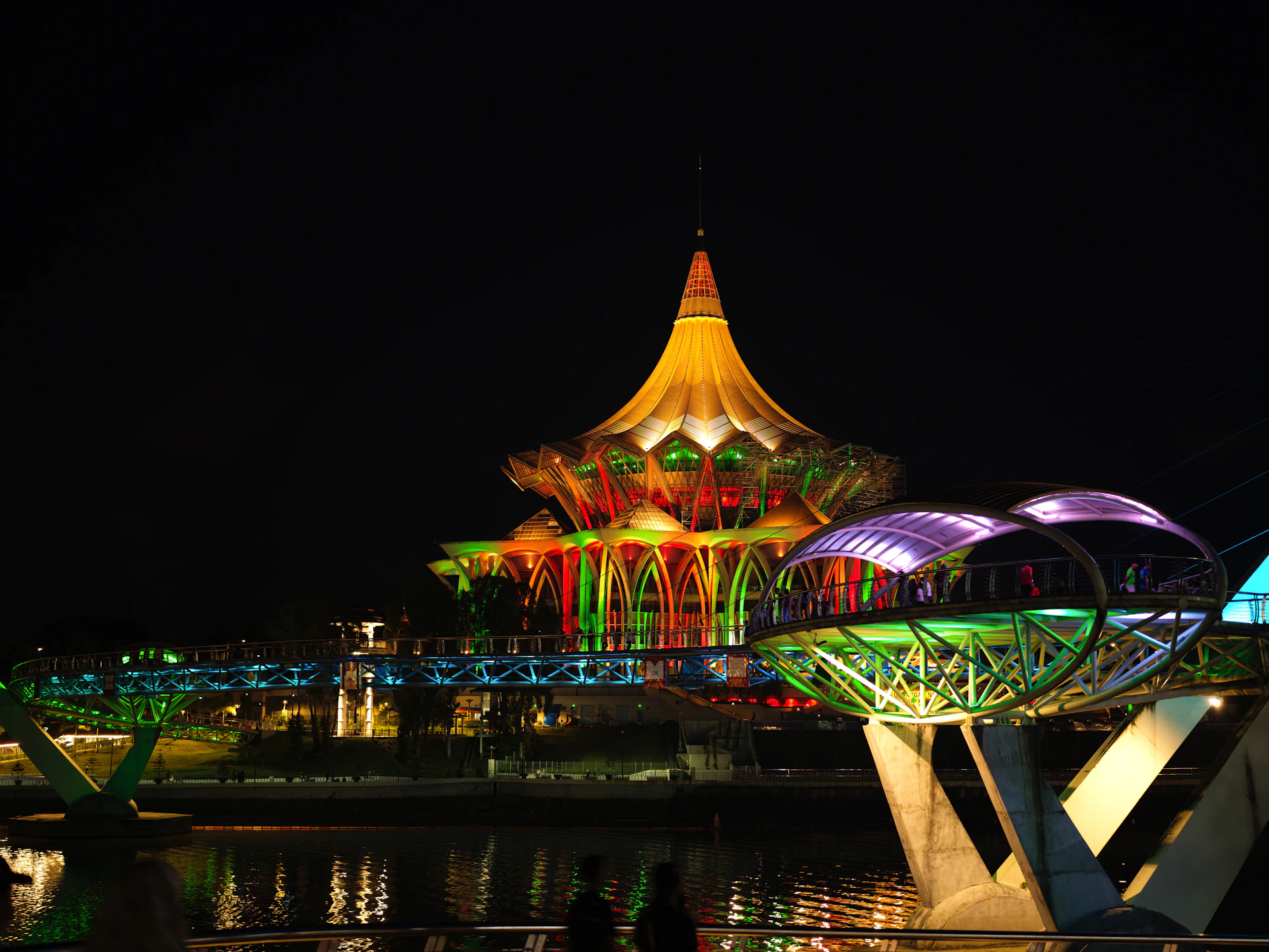 A building and bridge are illuminated at night