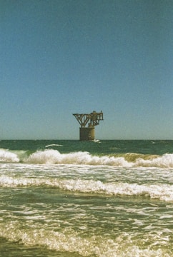 An old structure stands alone in the ocean.