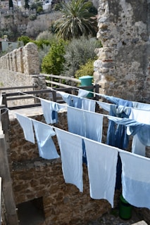 Laundry hangs out to dry near an old stone wall.