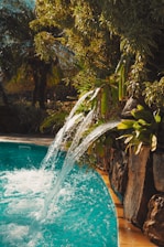 Water cascades into a turquoise pool in nature.