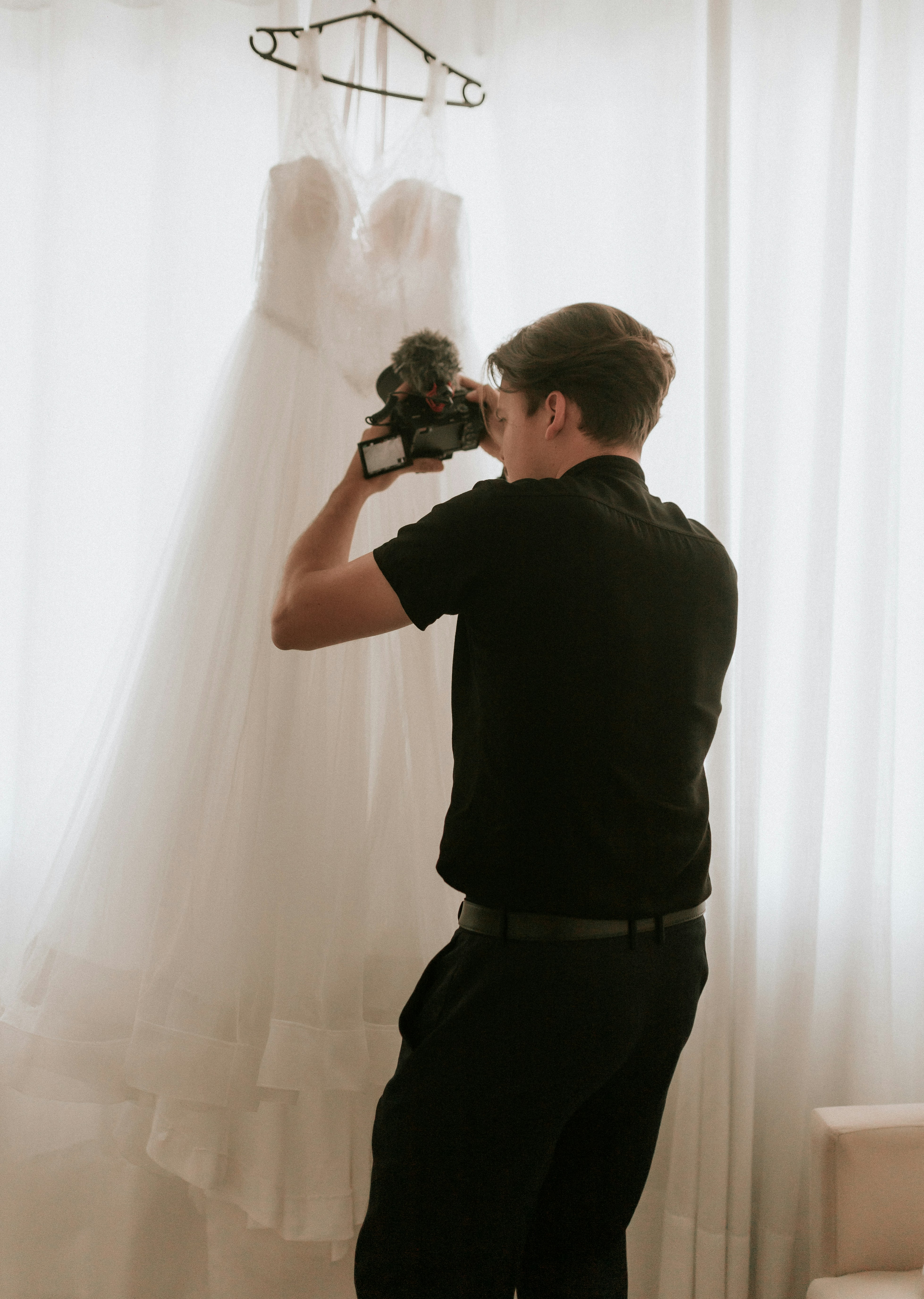 Photographer captures a photo of a wedding dress.