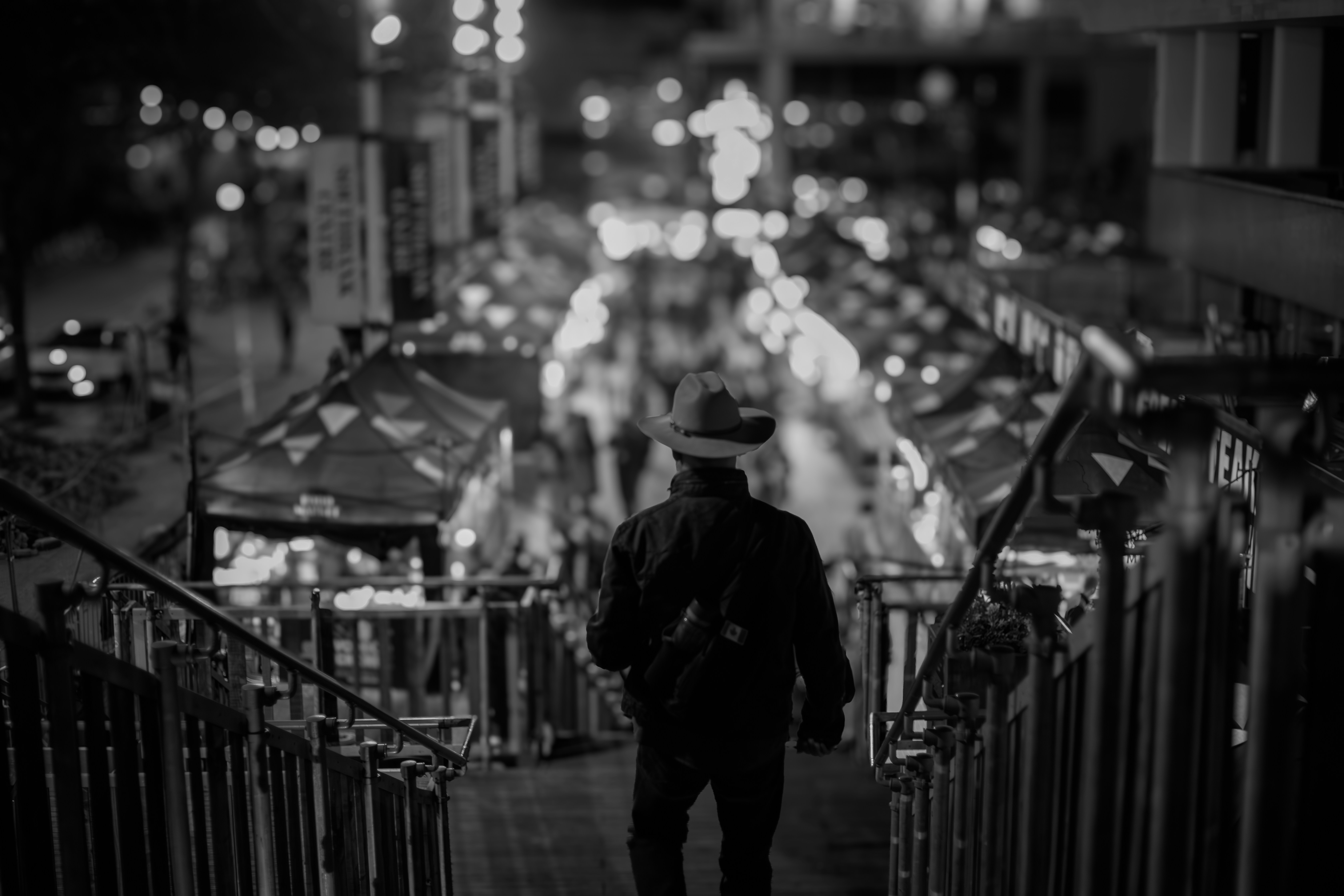 Man walks down stairs toward night market.