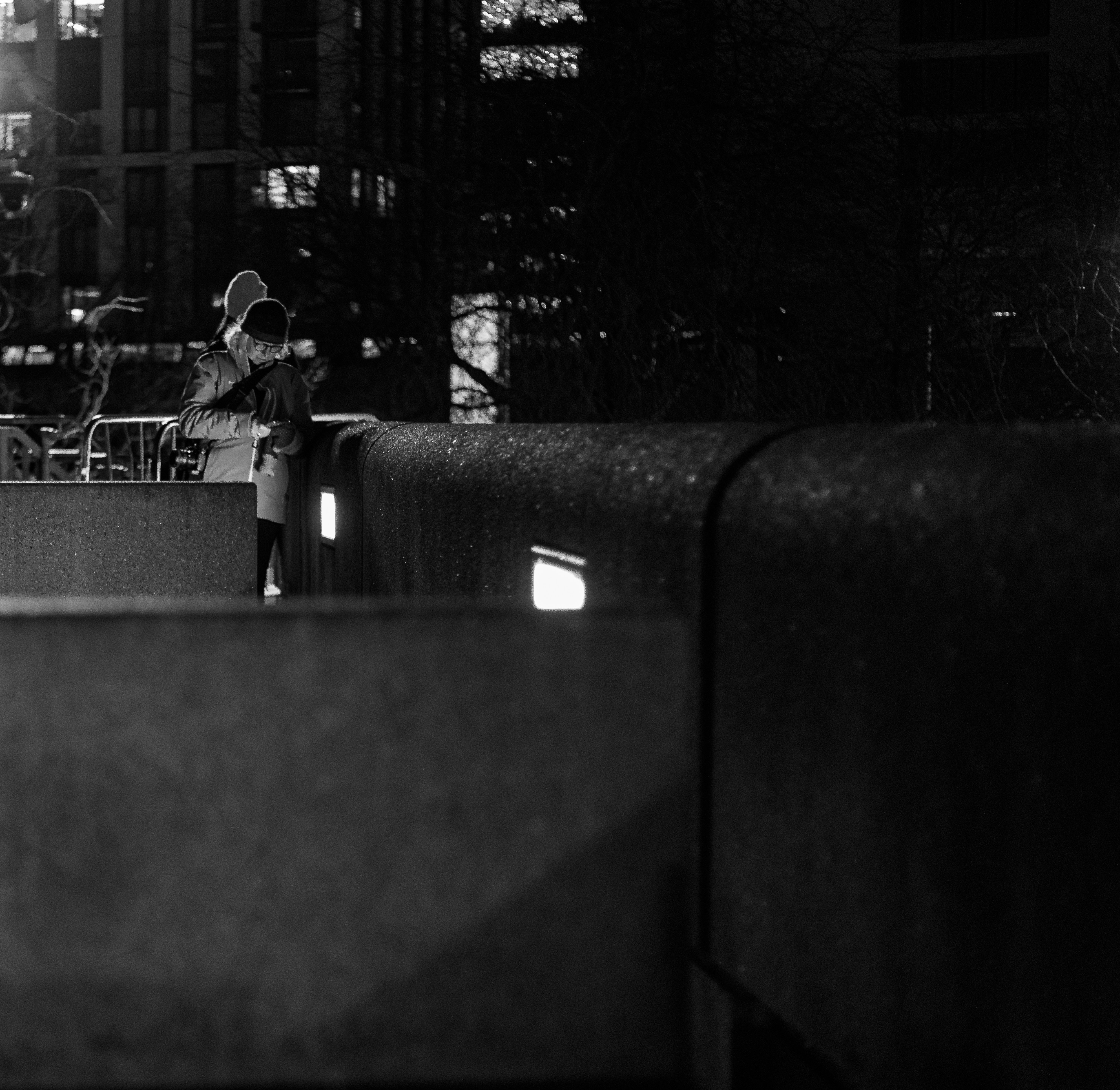 Person standing on a wall at night.