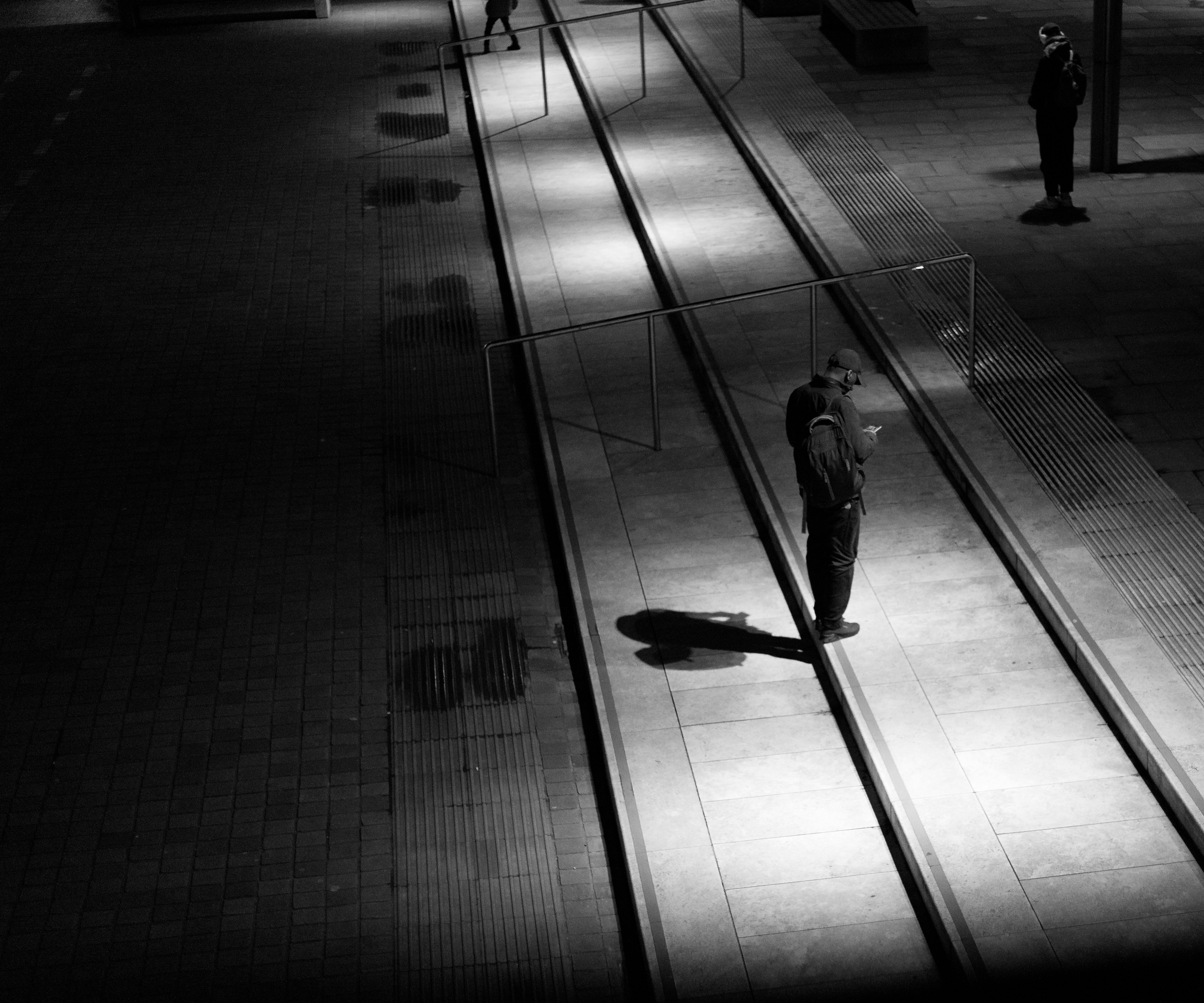 People stand on a train platform at night.