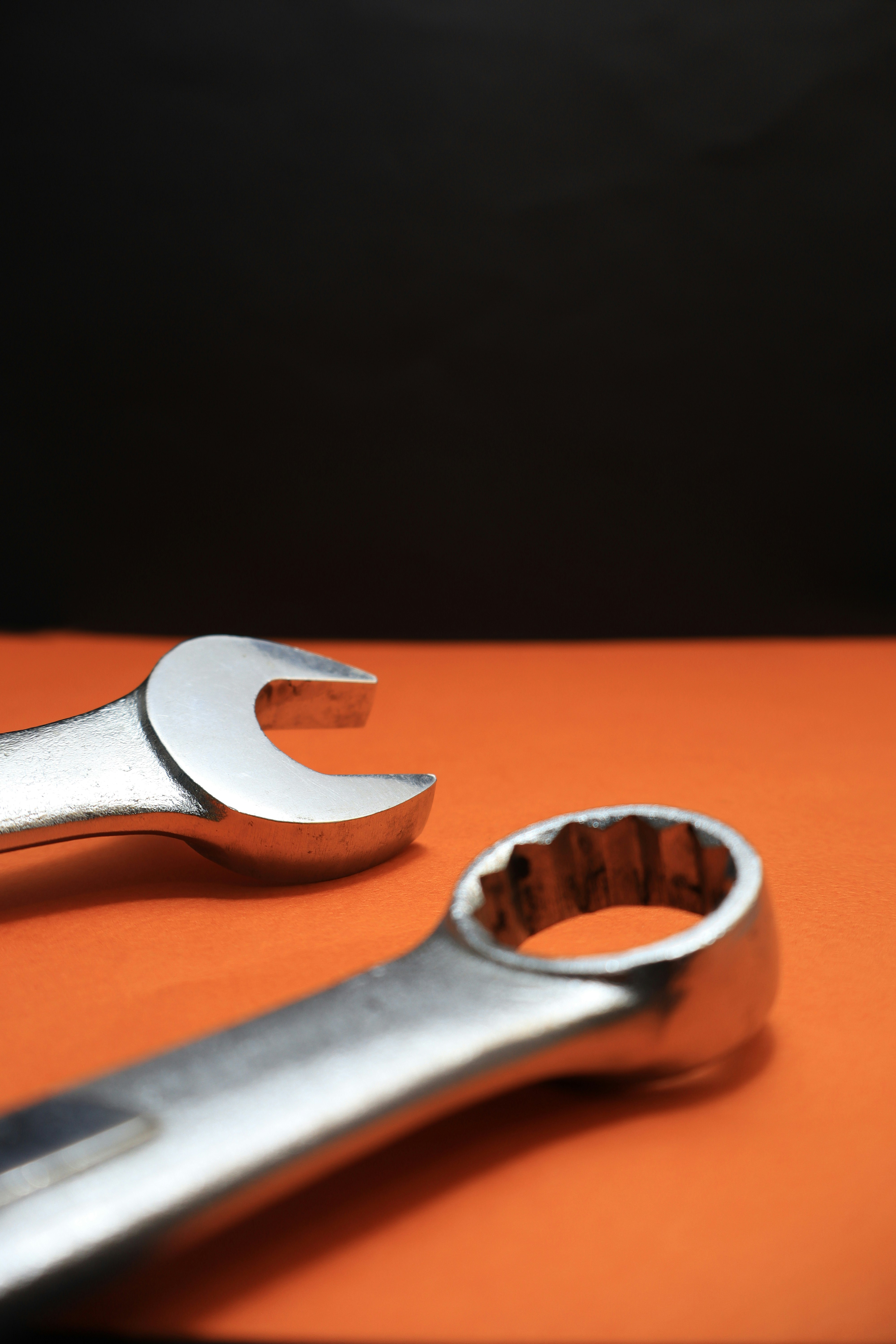 Two wrenches rest on an orange surface.