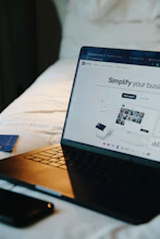 Laptop, phone, and card on a bed