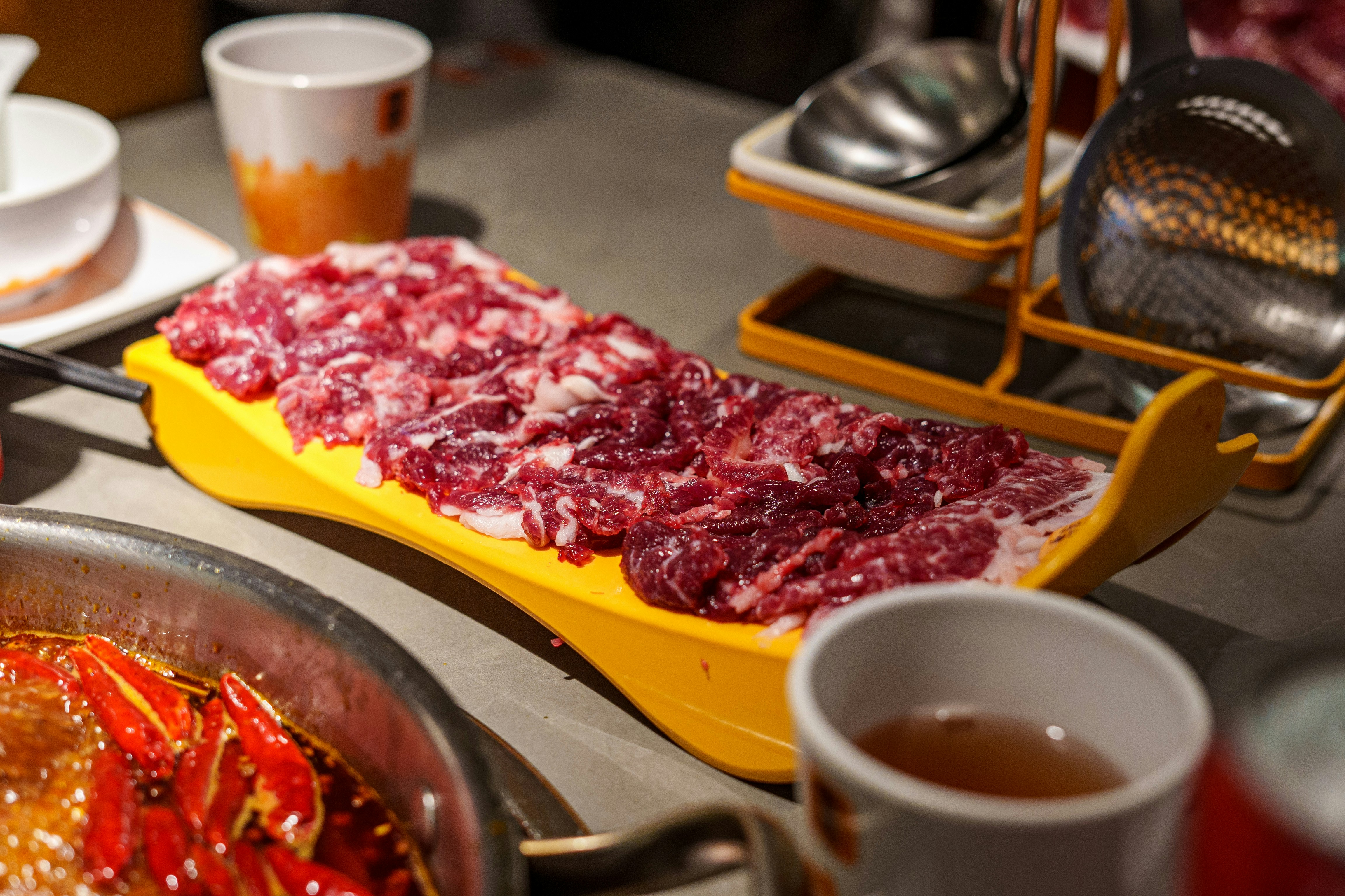 Raw sliced meat ready for a hot pot at a table