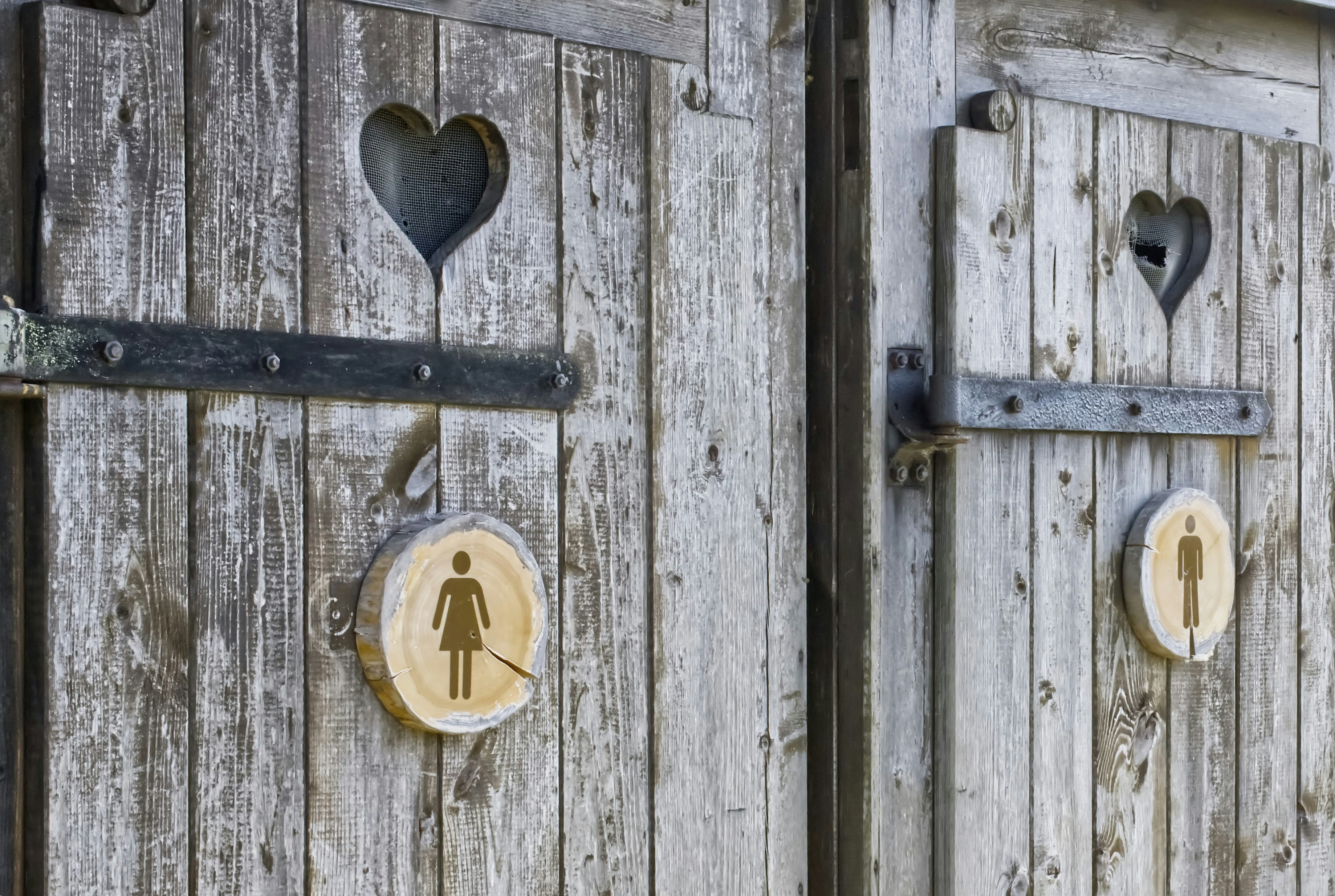 Las letrinas rústicas de madera marcan los baños de género.