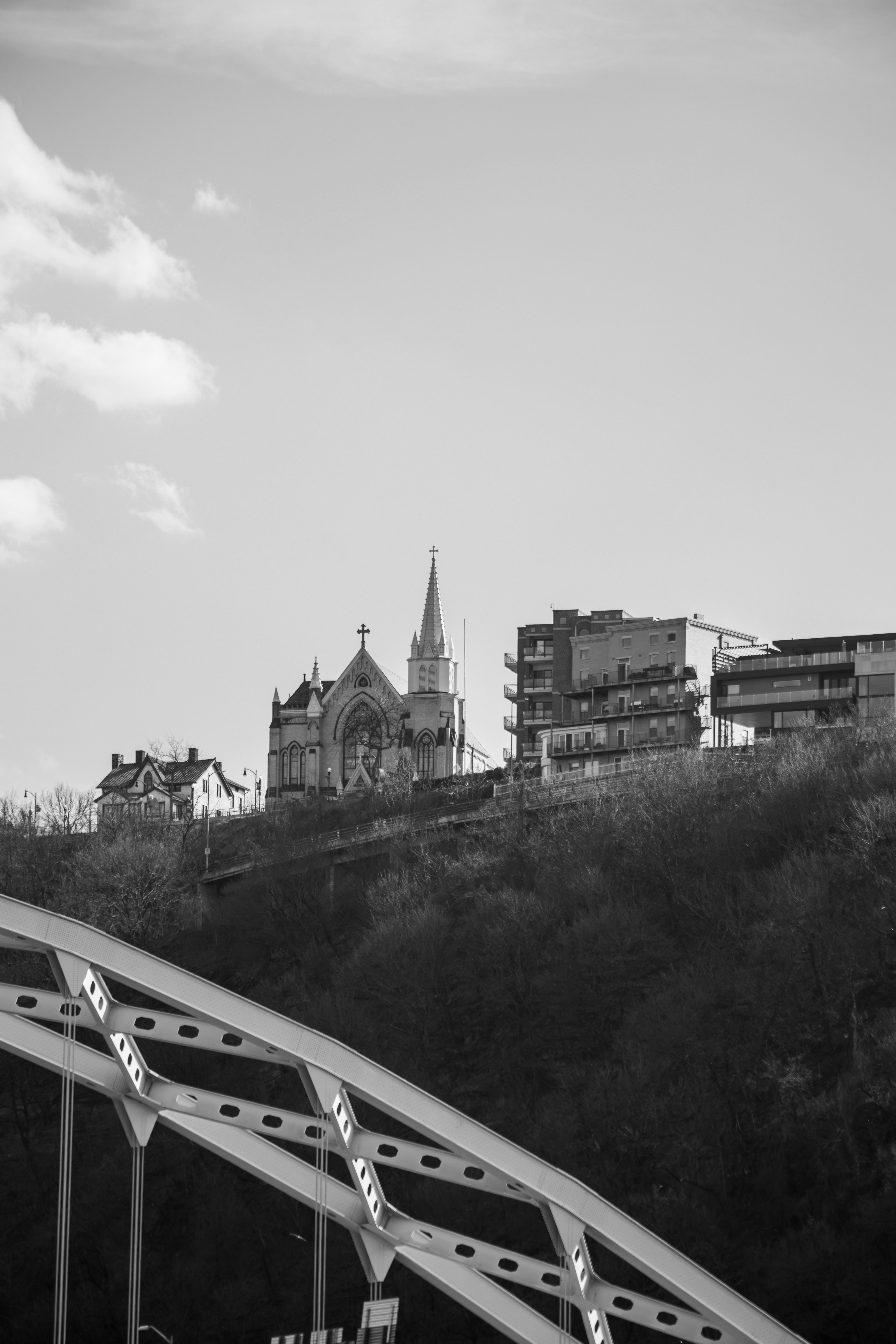 A church and buildings sit atop a hill.