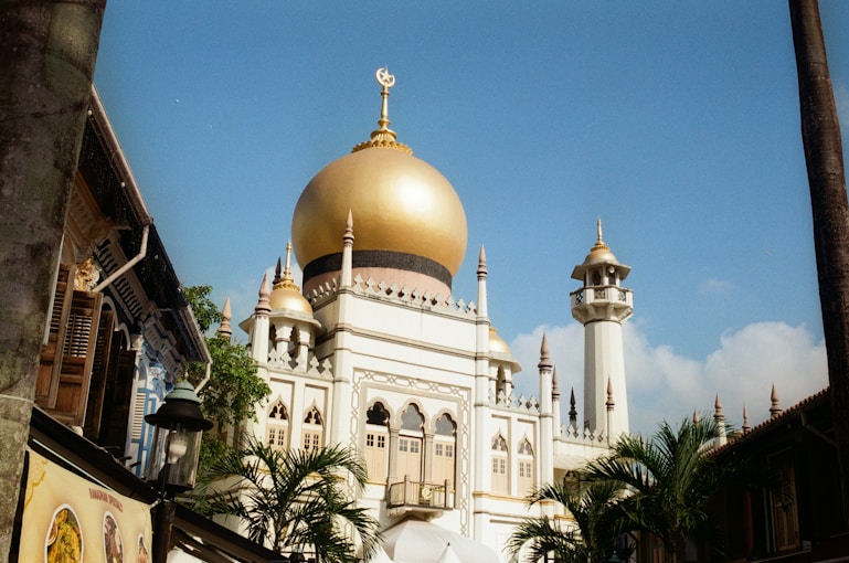 A golden domed mosque under a bright blue sky.