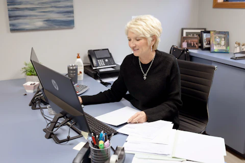 Woman works on laptop at her office desk.