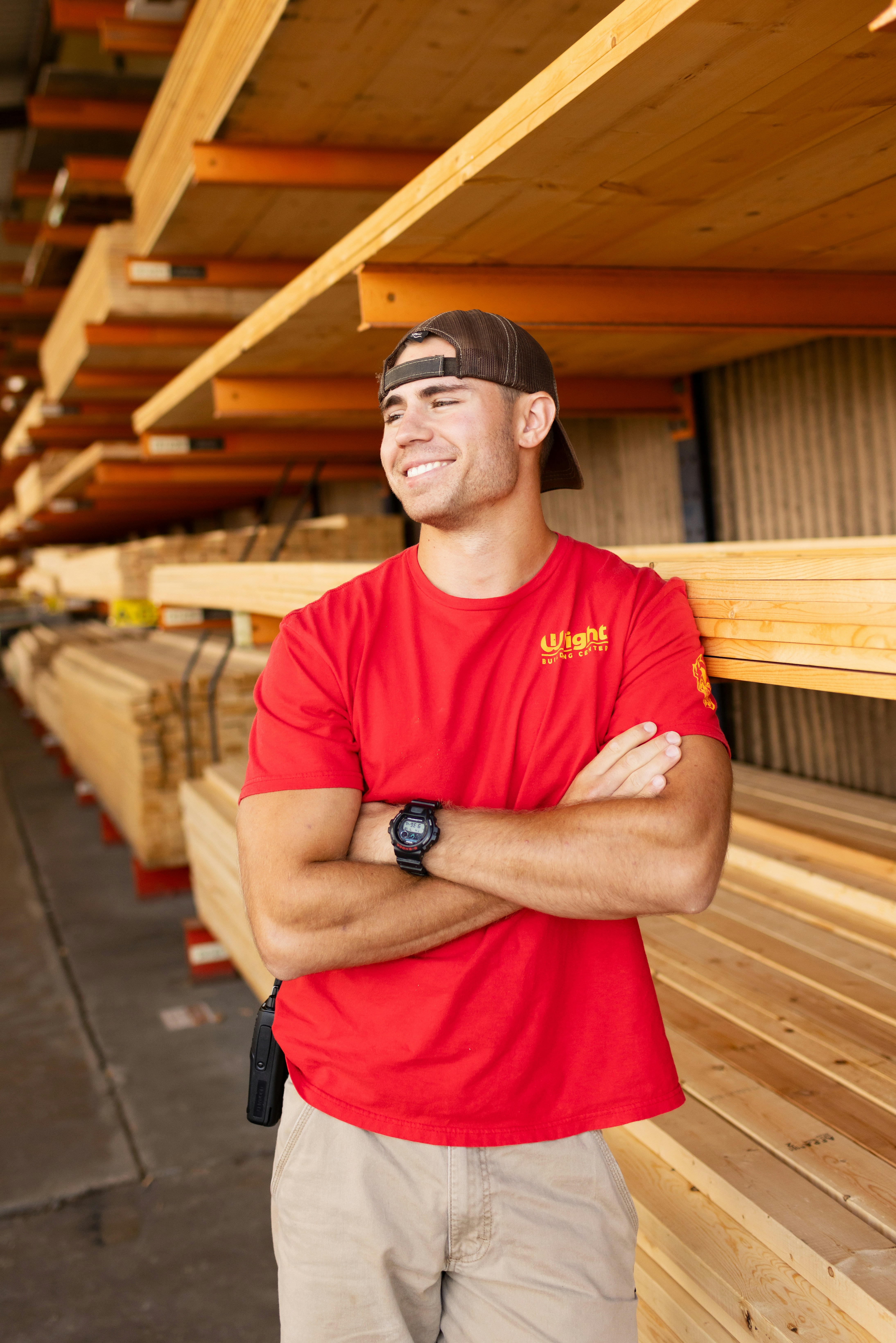 A lumberyard worker smiles while looking off camera.