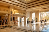 A grand hotel lobby filled with sunlight.