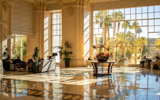 Elegant lobby with large windows and sunlight.