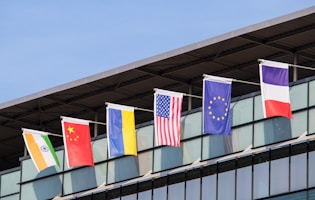 Flags of various nations fly on building.