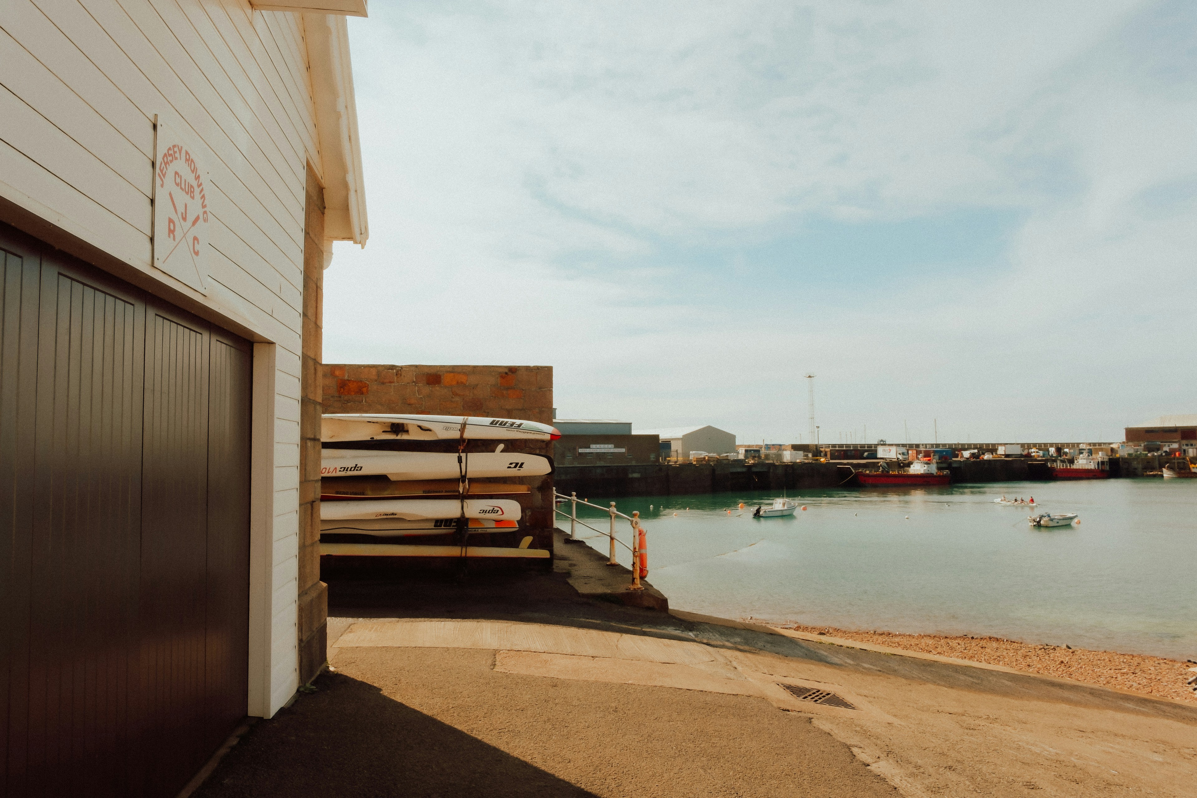 Ein Bootshaus befindet sich neben einem ruhigen Hafen.