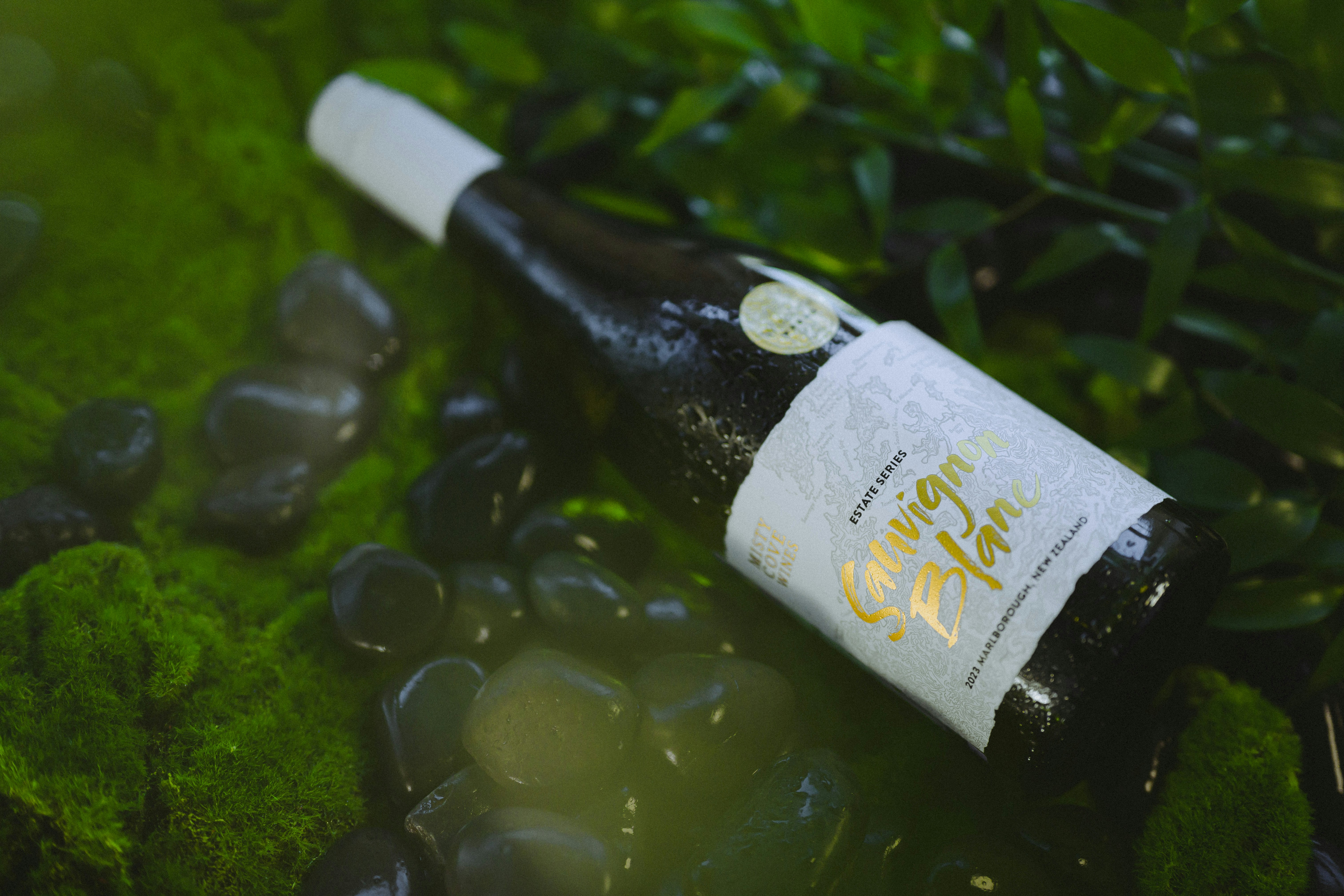 Wine bottle on a bed of moss and rocks.